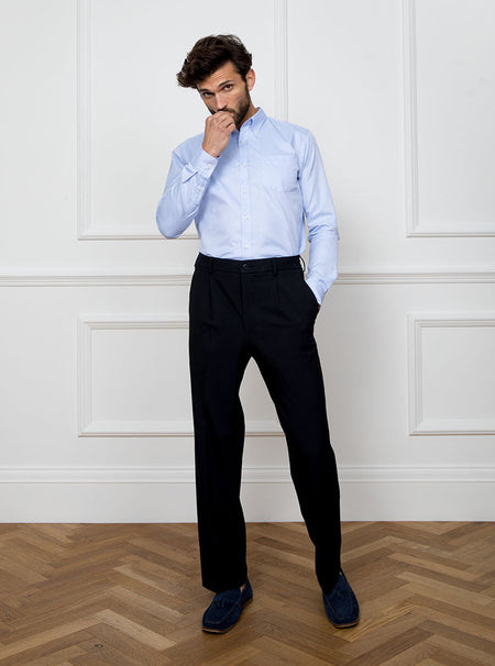 Man wearing a sky blue long sleeved shirt with a button down collar made with 100% Royal Oxford Cotton.